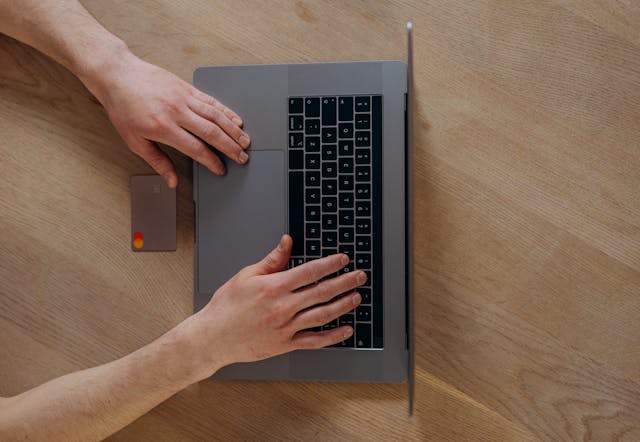 Person using a credit card and laptop for an online payment